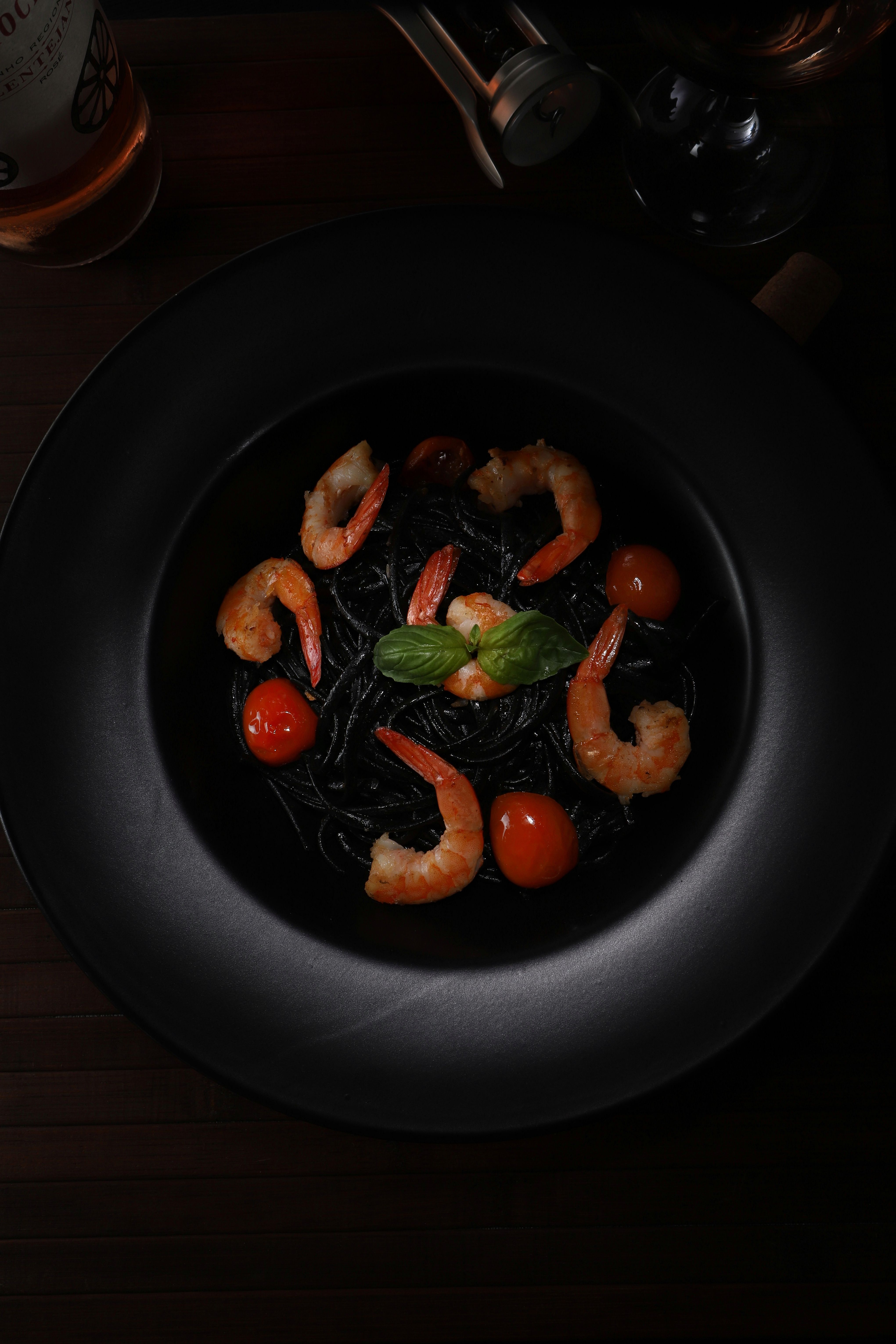 Pasta negra con langostinos servida en plato hondo