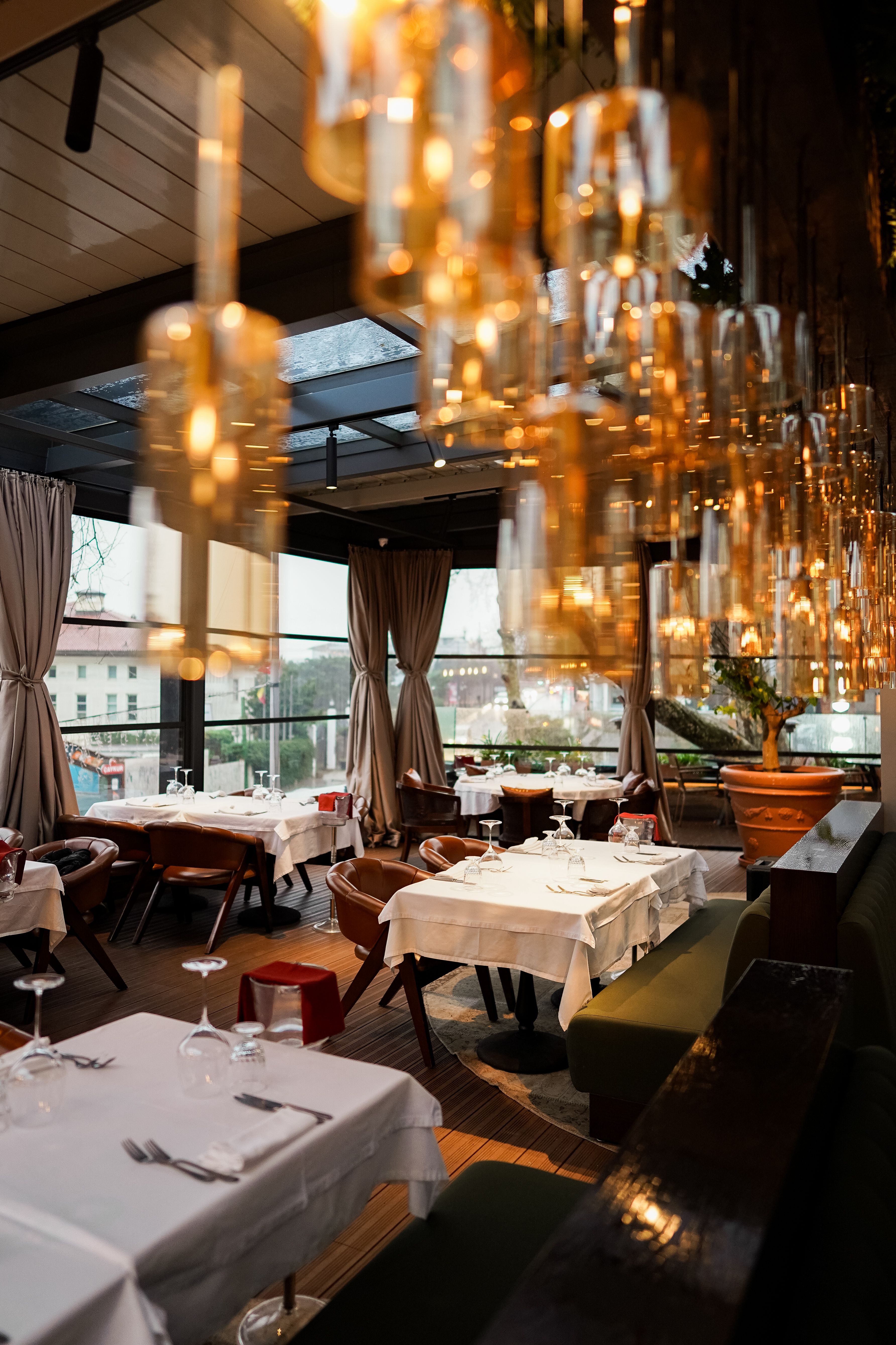 Comedor de restaurante con lámparas cálidas y mesas vestidas de blanco
